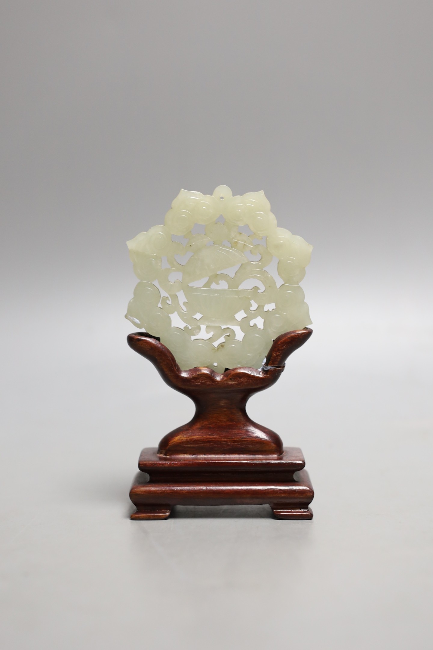 A Chinese pale celadon jade star shaped plaque, wood stand, 12cm